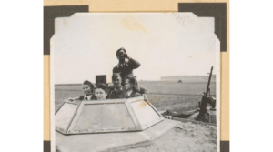 Zwart-wit foto met vier duitse soldaten die vanuit een tank in de verte kijken. Twee mannelijke soldaten en twee vrouwelijke.