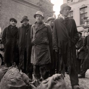 zwart wit foto van mannen in lange jassen en met hoed. 